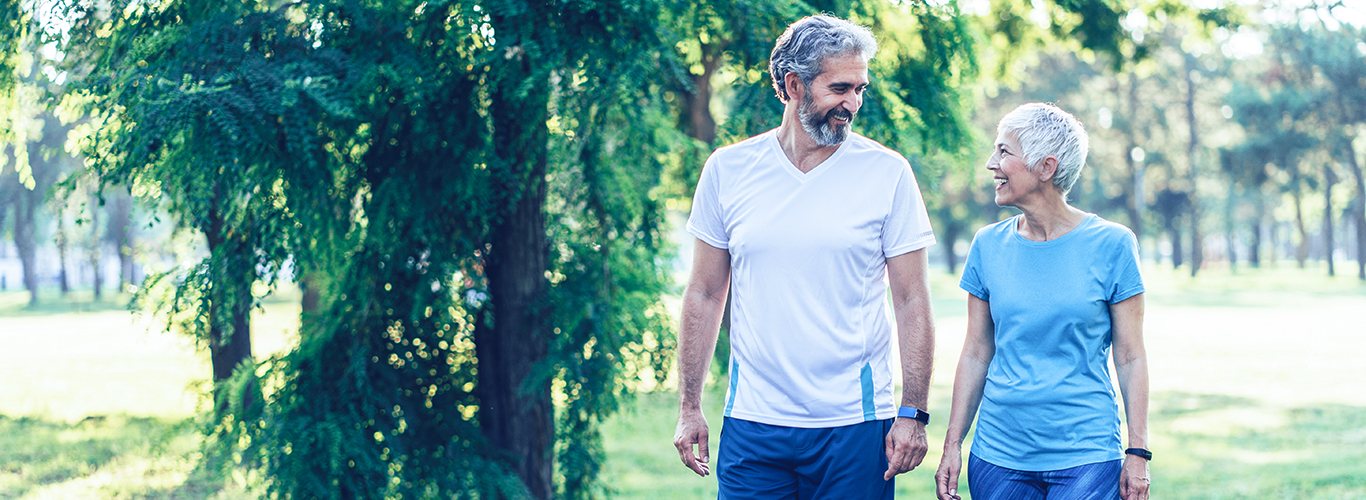Active mature couple having a walk in the park.
