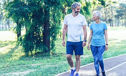 Active mature couple having a walk in the park.